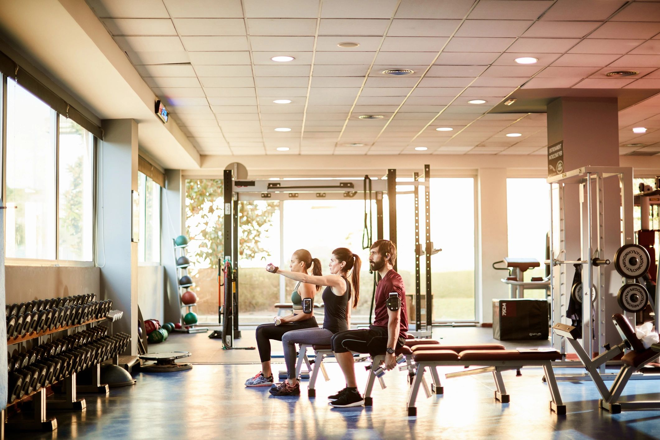 Wide-angle view of a gym with people lifting weights