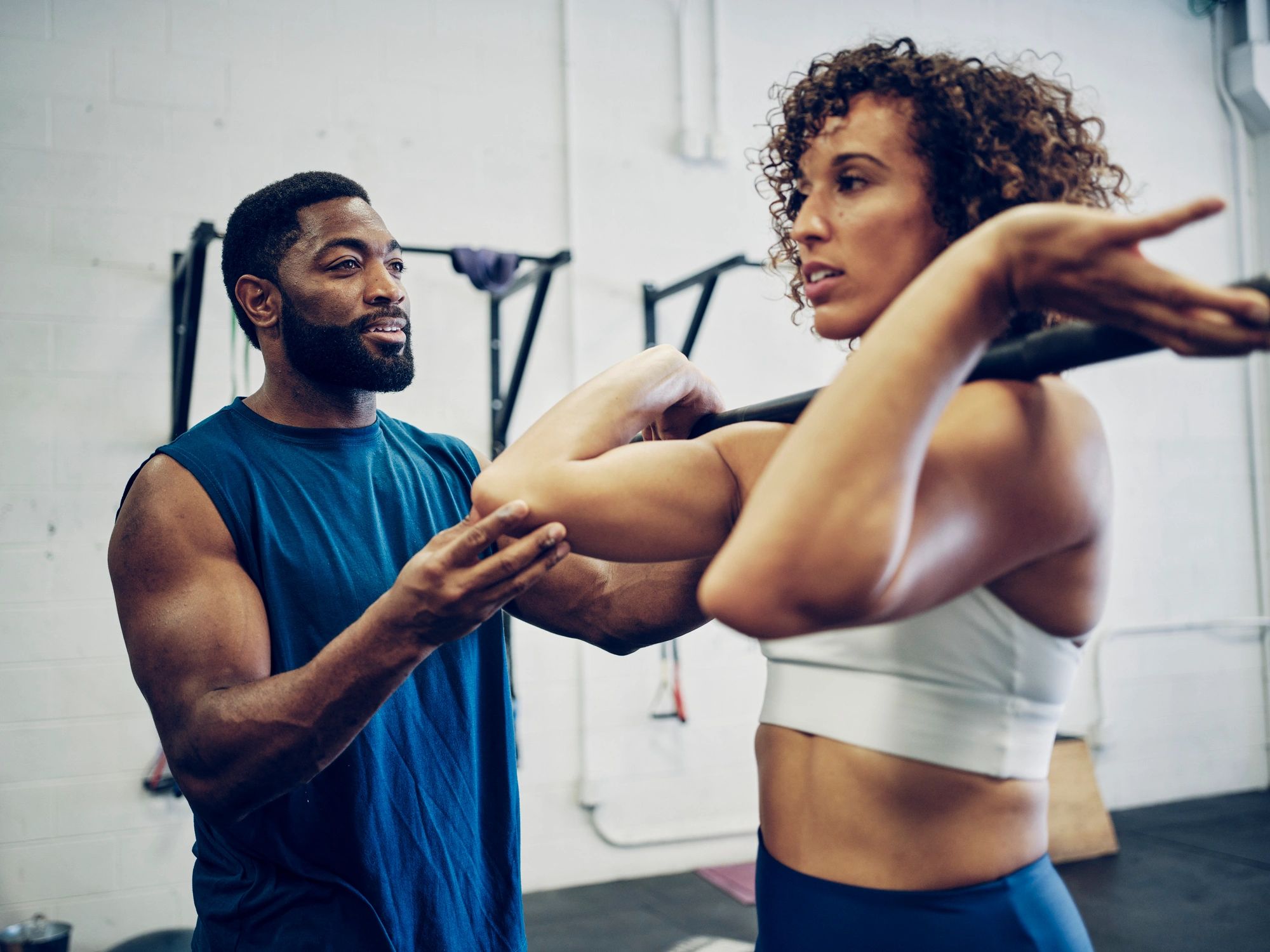 Trainer guiding a client through a strength training movement