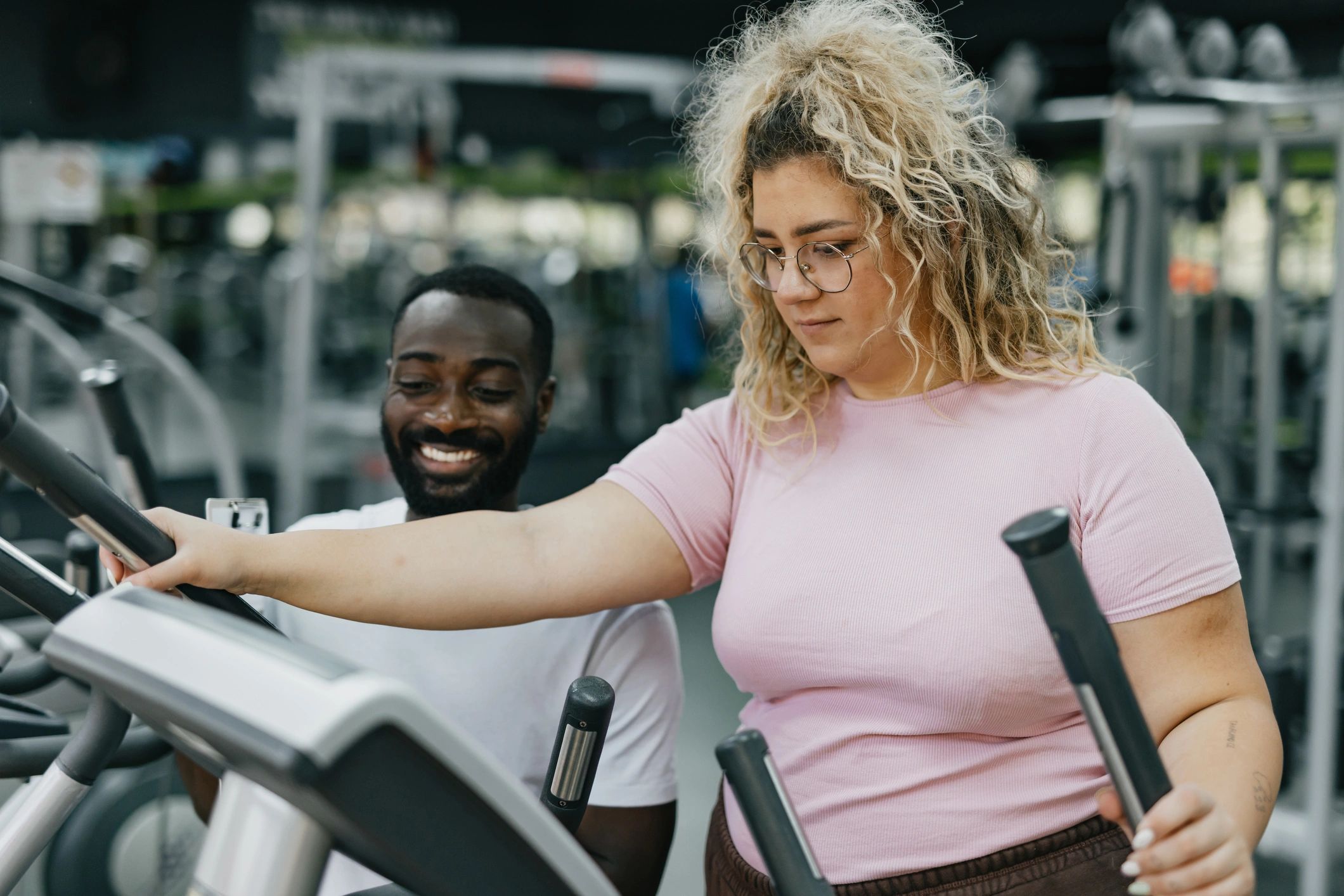 Trainer coaching a member on cardio equipment