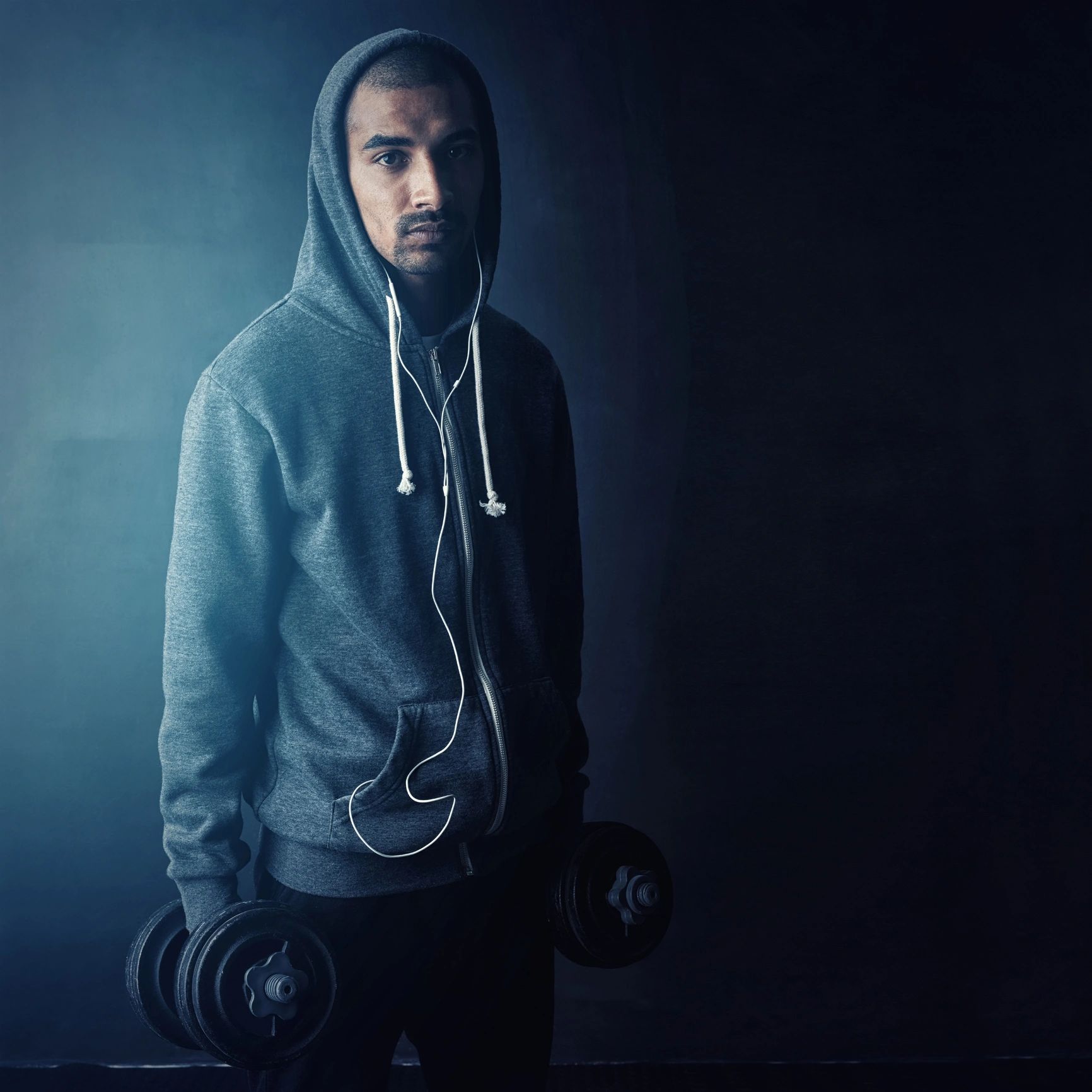 Portrait of a male athlete lifting weights in a studio